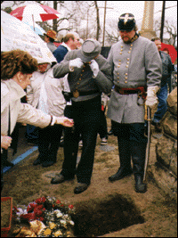 Alan Pickett watches as dirt is thrown into Mrs. Pickett's grave