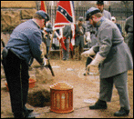 Gregory Collins and Collin Pulley prepare to lower the casket into the grave